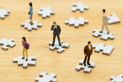 business people standing on puzzle pieces