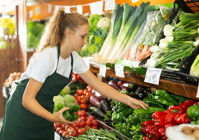 young female employee working in produce department