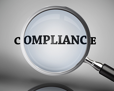 magnifying glass hovering over word "compliance"