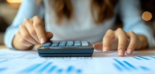 closeup of woman at desk using calculator